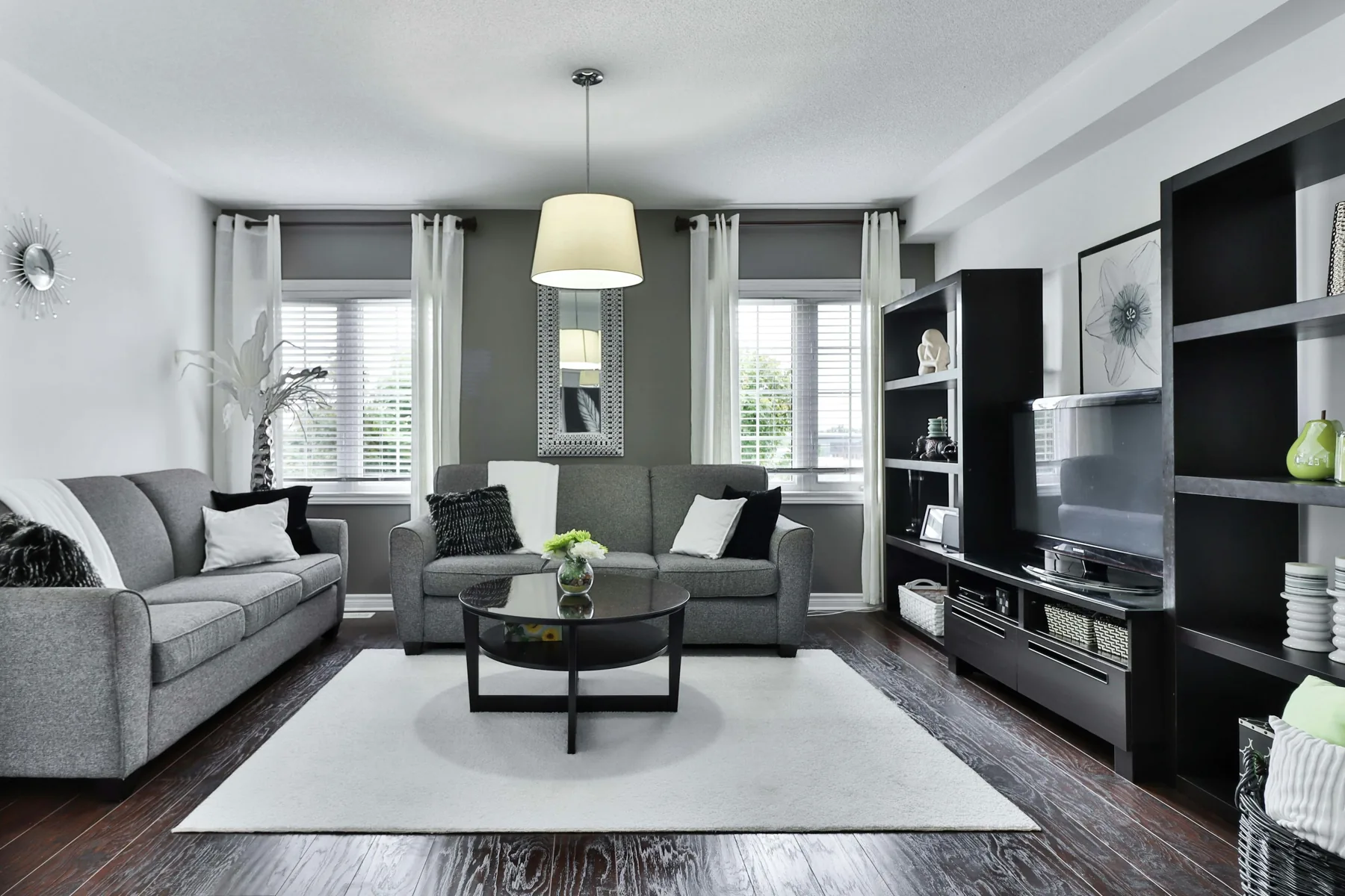Contemporary living room with a grey sofa and a glass coffee table.